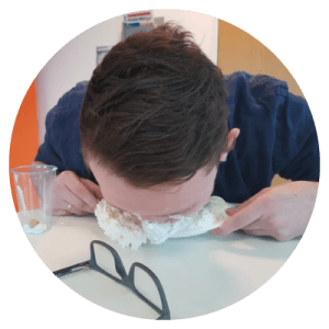 circular image of zest colleague participating in pie eating charity fundraising event