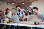 Seven people sat working at desks